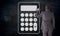 Businessman paints calculator icon on blackboard concept