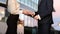 Businessman pays businesswoman in euros and they shake hands aft