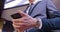 Businessman phone conversation. A young man stands in suit in the office near the window and puts the phone in his