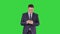 Businessman on the phone typing text message walking on a Green Screen, Chroma Key.