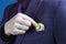 Businessman placing a Bitcoin in his jacket pocket in a close up view on his fingers and the coin.