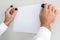 Businessman placing blank sheet of paper on white magnetic board