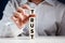 Businessman placing cube on top of tiered wooden cubes and completing the word trust. Building trust in business