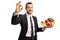 Businessman with a plate of fruits and vegetables gesturing a sign for perfect with hand