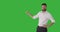 Businessman pointing over green chroma key background