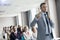 Businessman pointing while speaking through microphone during seminar in convention center