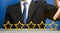 Businessman points to the fifth star. The concept of the rating of hotels and restaurants. The evaluation of visitors. Quality