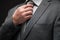 Businessman portrait dressed in gray suit, dark wall background