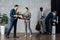 Businessman presenting flowers to smiling businesswoman with multiethnic colleagues on background in