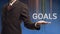 Businessman presents a word goals with his own hands
