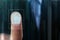 Businessman pressing control glass of biometric fingerprint scanner, closeup