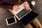 Businessman printing on laptop with blank screen, digital tablet and coffee