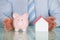 Businessman Protecting Piggy Bank And House Model
