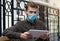Businessman in protective mask read online newspaper via tablet computer