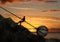 Businessman Pull Uphill A Big Rock With Chain In Front Of Sunset