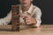 Businessman pulling a jenga wooden box,financial risk management and strategic planning,through data analysis for continuous