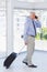 Businessman pulling suitcase and talking on phone