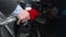 Businessman pulls out gasoline pistol fueling car petrol station