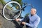 Businessman pumping up tires on bicycle