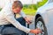 Businessman pumps car tire pump