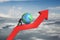 Businessman push globe upward on red trend line