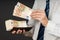 Businessman putting banknotes in his wallet. Stack of fifty euros money. Business man is holding cash. Person pays in euro bills