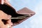 Businessman putting or taking out or paying Indian rupee banknotes from leather wallet. Isolated white background. Earning crisis