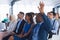 Businessman raising his hand while attending business seminar