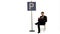 Businessman reading a book near parking sign on