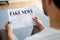 Businessman Reading Fake News Article On Newspaper