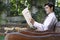 Businessman Reading Newspaper On Park Bench