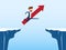 Businessman with red arrow sign jump through the gap between hill. Running and jump over cliffs. Business risk and success concept