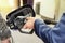 Businessman refuel his car. Close up of a mans hand in blue suit refilling the car with a gas pump