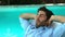 Businessman relaxing on deckchair poolside