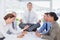 Businessman relaxing on the desk with upset colleagues around