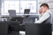 Businessman resting in armchair in office