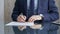 Businessman reviewing documents at office desk. Close-up of a professional man's hands examining paperwork with pen