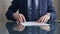 Businessman reviewing documents at office desk. Close-up of a professional man's hands examining paperwork with pen