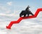 Businessman riding bear on arrow downward trend line with sky