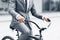 Businessman riding to work on bike, holding hands on handlebar