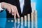 Businessman`s Fingers Walking Up Stack Of Coins At Desk