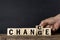 A businessman`s hand flips over a wooden cube whose word has been changed to opportunity