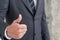 Businessman`s hand showing thumb up signal for positive agreement or confirm successful negotiation.Thumb up finger is body