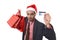 Businessman in Santa Claus Christmas hat holding sopping bags and credit card in worried and stress