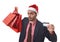 Businessman in Santa Claus Christmas hat holding sopping bags and credit card in worried and stress