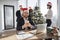 Businessman in Santa hat sitting at table and using modern smartphone.