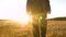 Businessman in serious suit with briefcase in hand walks along road in evening in glare of setting sun. farmer, and