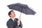 Businessman sheltering under black umbrella