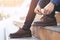 Businessman in a shirt jeans tie up shoelace on wearing brown leather shoes sitting staircase background. Men`s style.