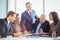 Businessman showing file to coworkers in conference room